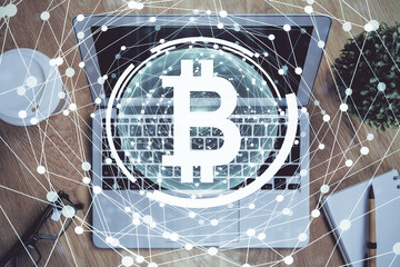 Multi exposure of blockchain theme hologram and table with computer background. Concept of bitcoin crypto currency.