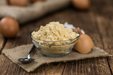Old wooden table with fresh Powdered Eggs (close-up shot; selective focus)