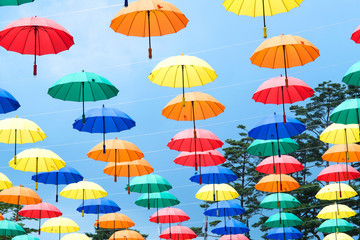 Fototapeta na wymiar Colorful umbrellas background. Multicolored umbrellas hanging above the street. 