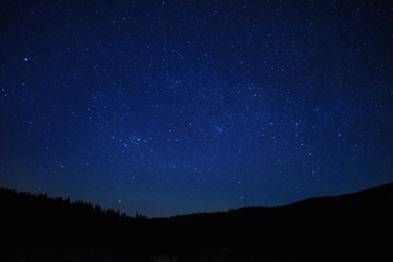 Calm night with shiny stars in the mountains.