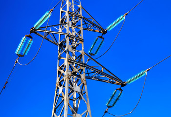 A pylon of overhead power line on blue sky