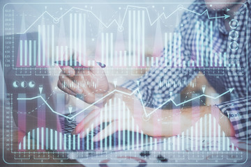 Double exposure of forex graph with man working on computer on background. Concept of market...