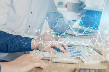 Multi exposure of chart with man typing on computer in office on background. Concept of hard work.