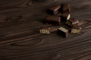 chocolate candies with nut filling on a brown wooden background, close-up