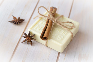 Bars of soap with cinnamon on wooden shabby background