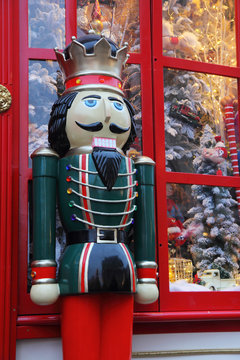 The Statue Of The Nutcracker Standing By The Window Of A Christmas Toy Shop