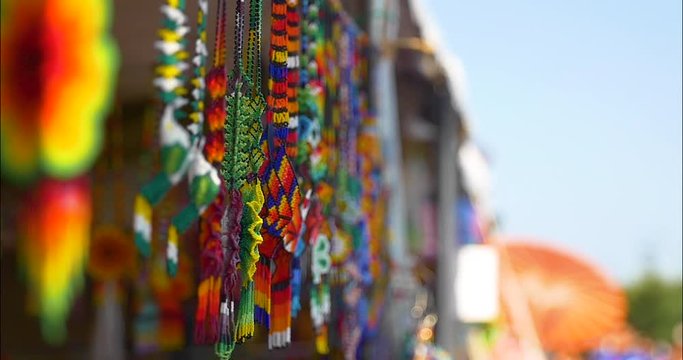 Huichol Traditional Mexican art. Beaded necklaces and bracelets, other jewelry shine in the sun on a summer day. Pictured at a local street fair for artisans to share and sell their works.