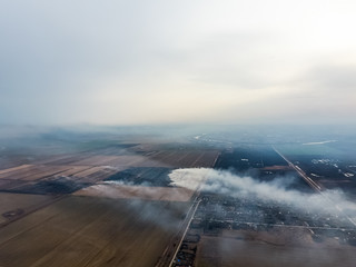 Top view of the small village. Smoke from the burning of straw i