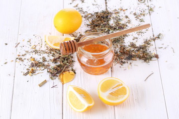 Honey with lemons on a white wooden table