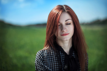 Naklejka premium The girl with the field on a background. Freckled girl. The girl is dressed in an old dress in a section.