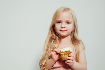 beautiful little girl blonde with cake and candy portrait of food