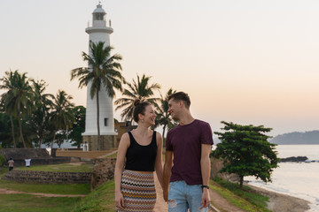 Couple in love walking in front of the lighthouse of Galle