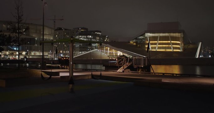Wide angle 4K shot with slow reveal parallax motion of the illuminated Norwegian Opera House and the Edvard Munch Lambda gallery, at night in Bj&oslash;rvika Oslo Norway. Shot on professional cinema camera.