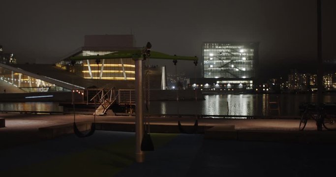Stabilized full angle 4K shot with parallax motion of illuminated Opera Theatre and Edvard Munch Museum Lambda with light reflecting in fjord, Bj&oslash;rvika Oslo Norway. Shot on professional cinema camera.