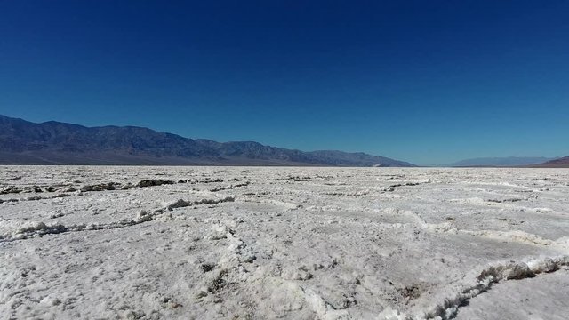 Hipster girl traveling in wild environment of lowest point of America using camera for making photos of landscape, skilled female photographer taking picture exploring arid lands of Badwater