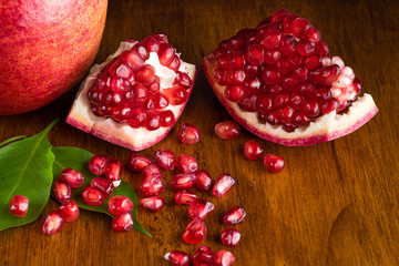 Split open Pomegranate fruit or Punica granatum on wooden table
