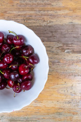 plate fresh red cherry. Seasonal berry picking in Europe copy space