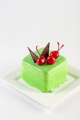 Sweet green mousse cake with chery on top