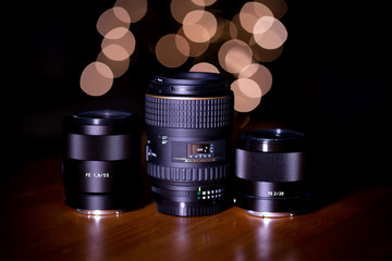 Camera Lenses on a Table with Background Bokeh Lights