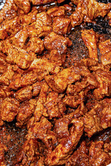 seasoned fresh roasted many pieces of pork on a frying pan background culinary