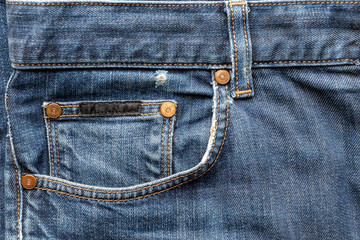 details of worn blue denim jeans pockets, worn edges