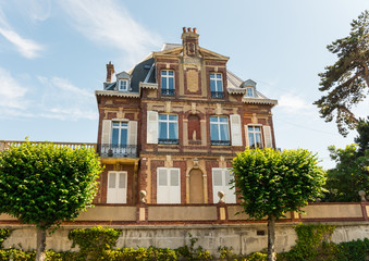 Beautiful typical manor in Cabourg, Normandy, France. Sunny summer day in the town of Marcel Proust. This mansion/villa/house has a unique architecture (red & white bricks). Rich belle epoque life.