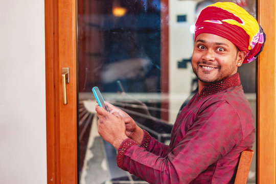 Smiling Indian Man Wearing Traditional Shalwar Kameez Using Smart Phone