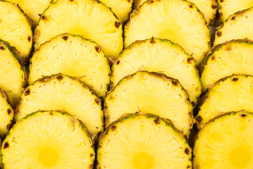 Pineapple juicy yellow slices background. Top view.