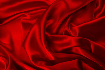 Red silk or satin luxury fabric texture can use as abstract background. Top view.