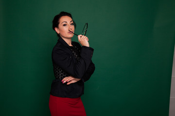 beautiful female teacher in business suit against a green background