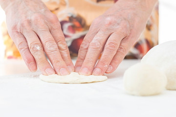 female hands knead the dough in the home kitchen. dough for making buns, pizza, chapatti. cooking love concept.