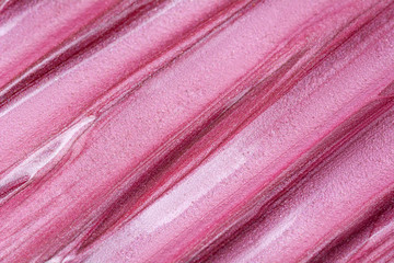 Texture of lip gloss. Smudged makeup product sample. Sparkling background