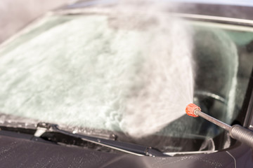 Woman washing car windshield