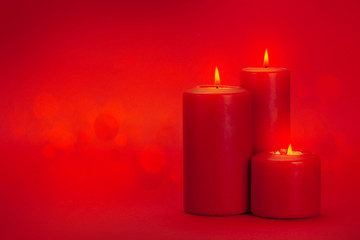 Valentines day greeting card with burning candles over red background with bokeh copy space for your greetings