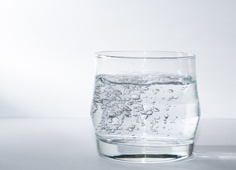 Kleiner Wasserglas gefüllt mit Wasser mit Sprudel