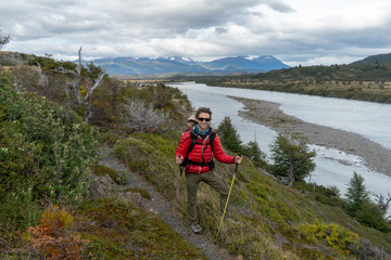Man hiking torres del paine in red jacket
