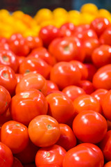 lots of tomatoes in the store. Showcase with tomatoes in a supermarket. A lot of red tomato. The choice of products. vegetables. vertical photo