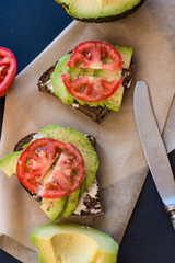 Tomato and Avocado on Toast, on a dark background.