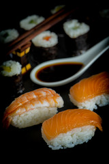 Salmon and prawns sushi  with soy sauce on a dark background.