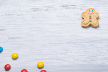 on a light gray background, cookies in the form of a snowman with icing and colorful dragees, in the middle there is a place for the inscription