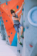 Fototapeta na wymiar Man on artificial exercise climbing wall