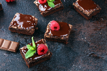 chocolate brownie cake dessert with raspberries and spices on a wooden background.