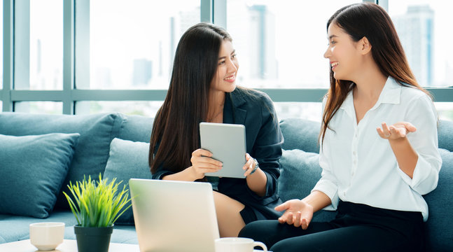 Two Asian businessmen Talk work in meeting room by Use the tablet to analyze business data. Teenage girls exchange knowledge and work to be successful, must have clear goal. concept of women's rights