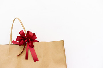 close up front view on shopping bag with red bow ribbon on white background with copy space for valentine's day , birthday and anniversary surprise concept