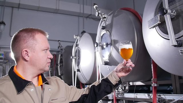 Small business and manufacturing concept. Brewers testing beer at brewery