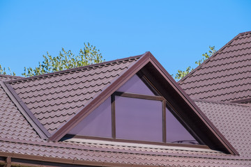 House with plastic windows and a brown roof of corrugated sheet