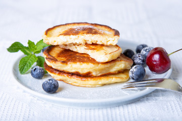 Cottage cheese pancakes (syrniki). Homemade cheesecakes from cottage cheese with berries. Traditional Russian dish. Close-up.