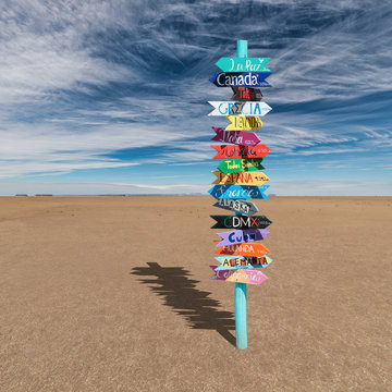 Colorful wooden direction sign with destination countries in empty desert 