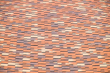 Roof from multi-colored bituminous shingles. Patterned bitumen shingles.