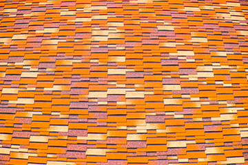 Roof from multi-colored bituminous shingles. Patterned bitumen shingles.